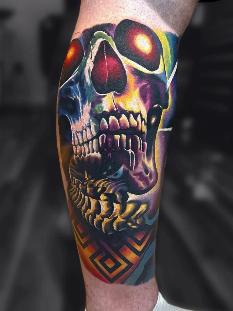 Autorski kolorowy realistyczny tatuaż przedstawiający czaszkę z geometrycznymi elementami wykonany przez Bartka w Studio Fortuna Tattoo w Warszawie.