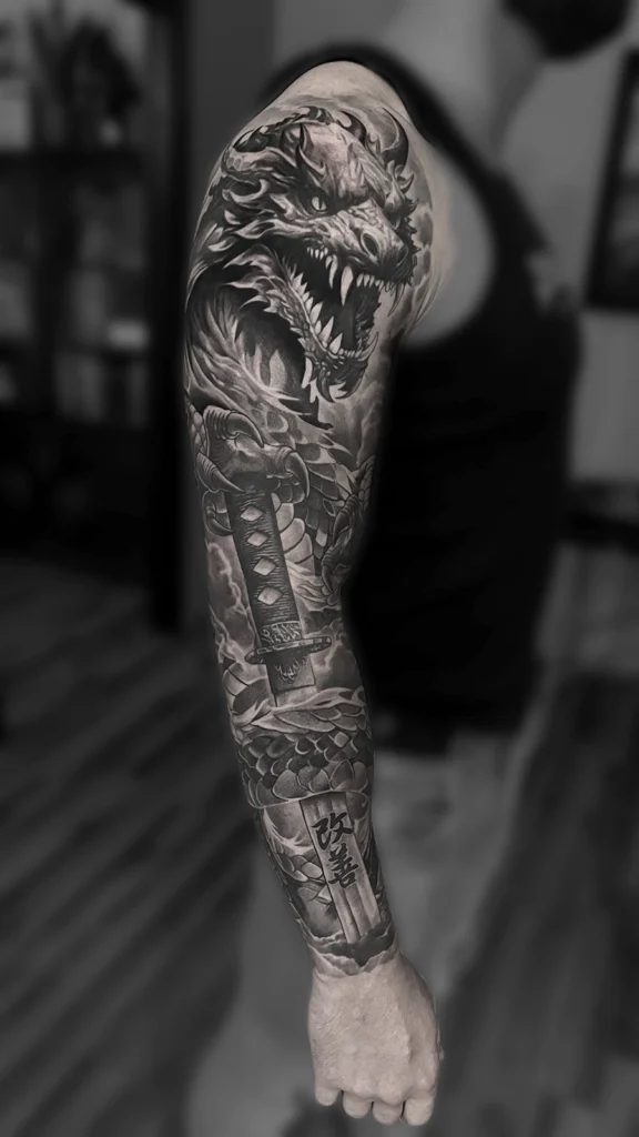 Tatuaż realistyczny black & grey przedstawiający smoka, miecz katana i motywy japońskie wykonany przez Bartka Fortunę w Warszawie.
