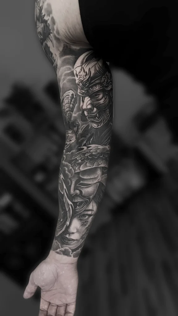 Tatuaż realistyczny black & grey przedstawiający samuraja, maskę Hannya, kobiecy portret i smoka wykonany jako rękaw przez Bartka Fortunę w Warszawie.