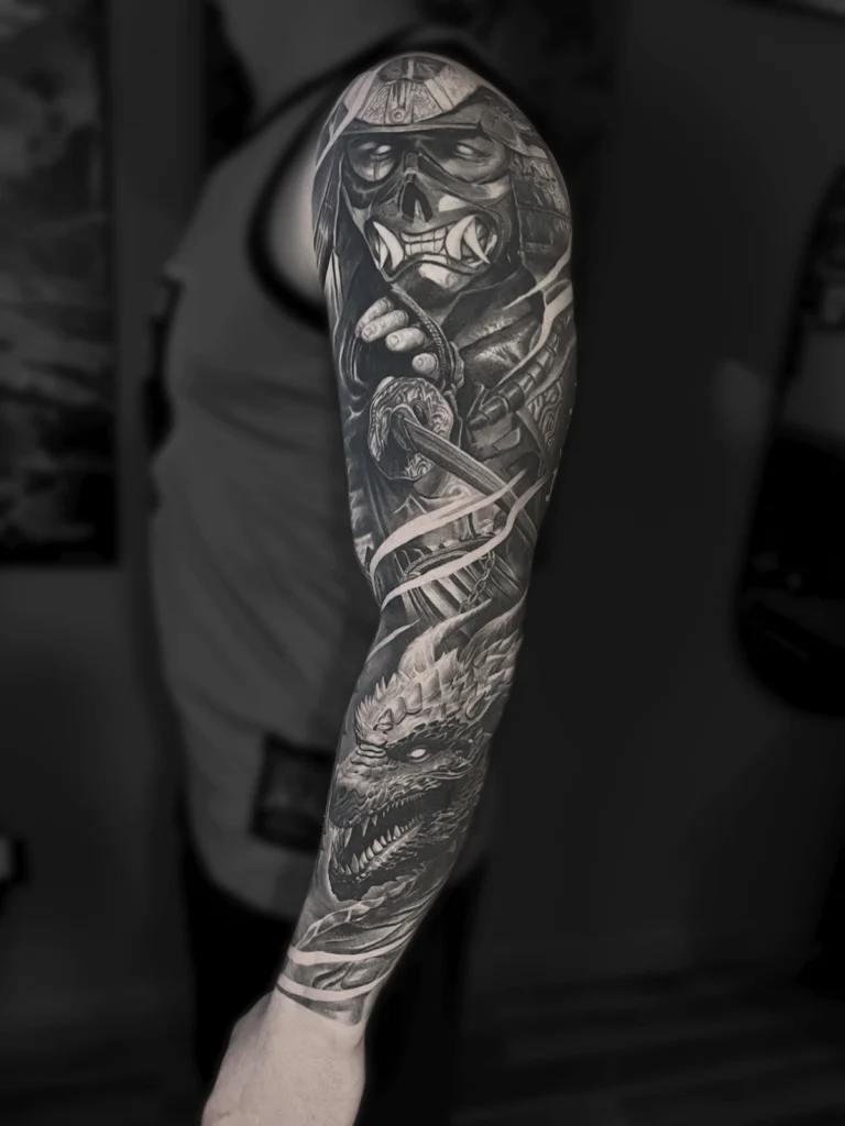 Tatuaż realistyczny black & grey przedstawiający samuraja w masce oni i smoka wykonany jako rękaw przez Bartka Fortunę w Warszawie.