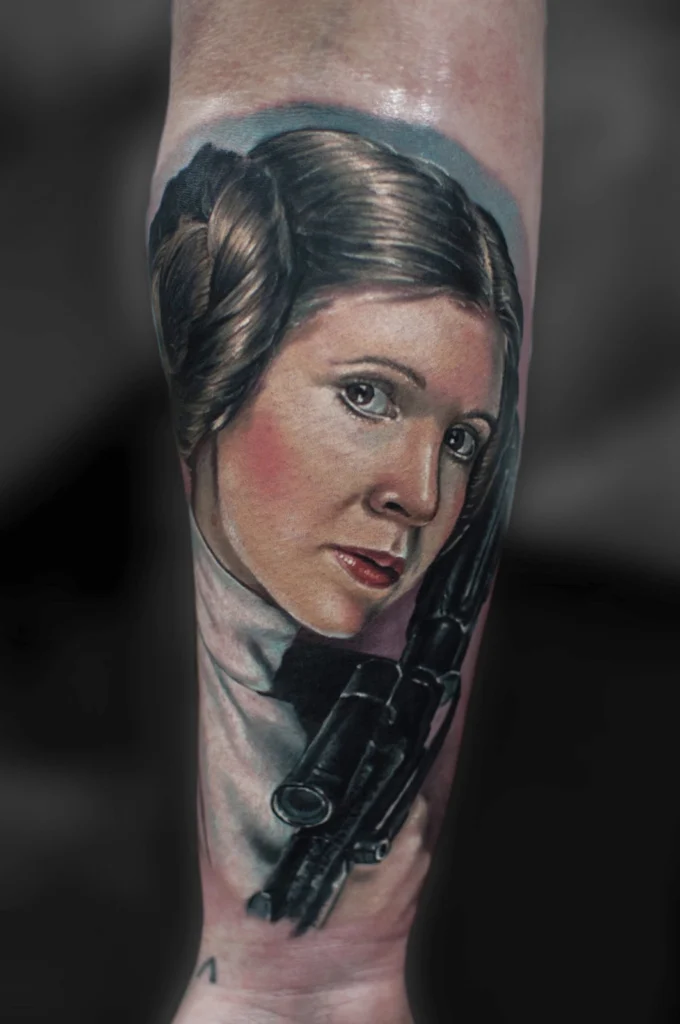 Kolorowy tatuaż realistyczny przedstawiający księżniczkę Leię z Gwiezdnych Wojen wykonany na przedramieniu w Studio Fortuna Tattoo Warszawa.