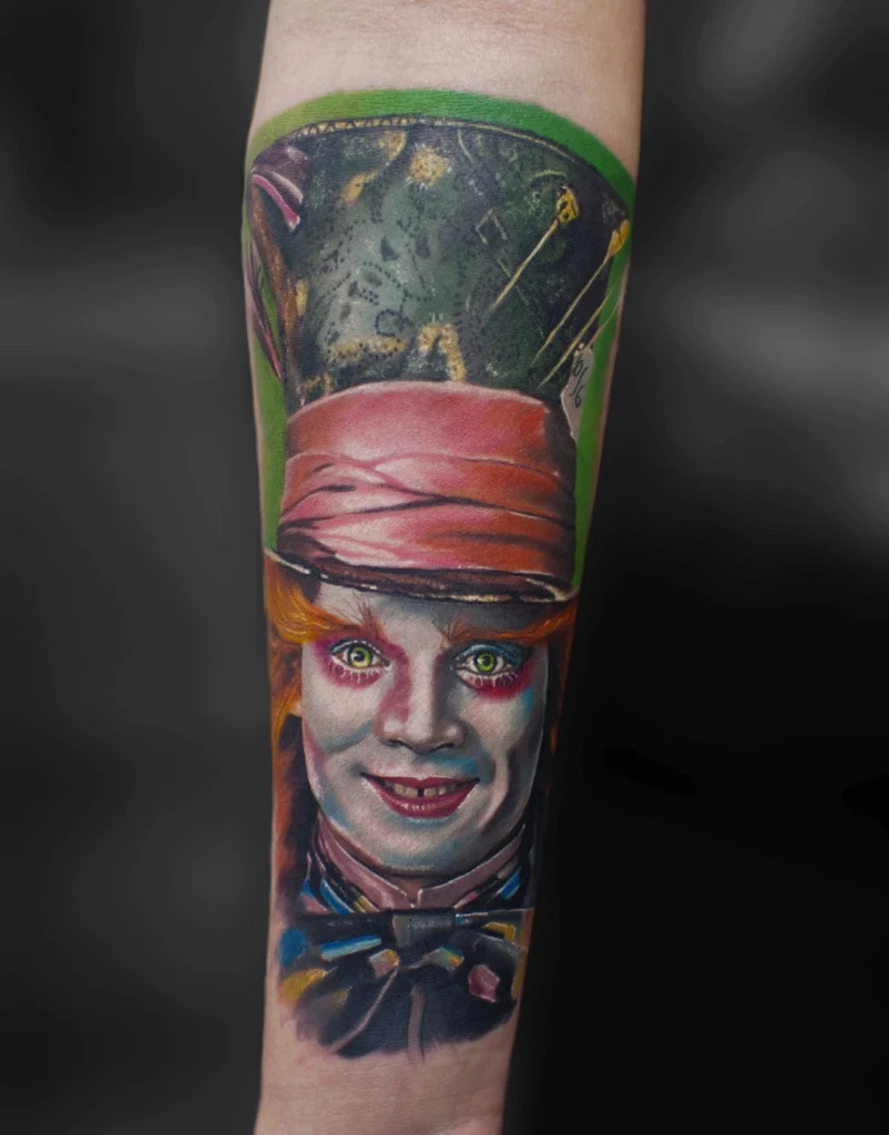 Kolorowy tatuaż realistyczny przedstawiający Szalonego Kapelusznika z filmu Alicja w Krainie Czarów wykonany na przedramieniu w Studio Fortuna Tattoo Warszawa.