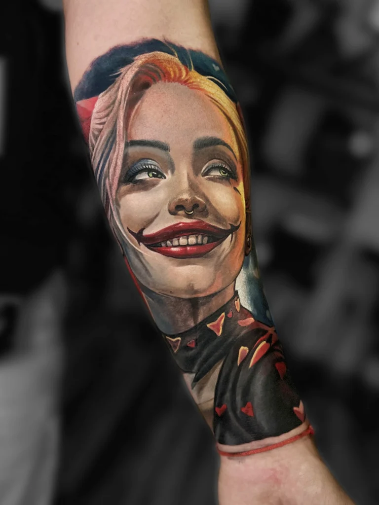 Kolorowy tatuaż realistyczny przedstawiający portret inspirowany Harley Quinn wykonany na przedramieniu w Studio Fortuna Tattoo Warszawa.
