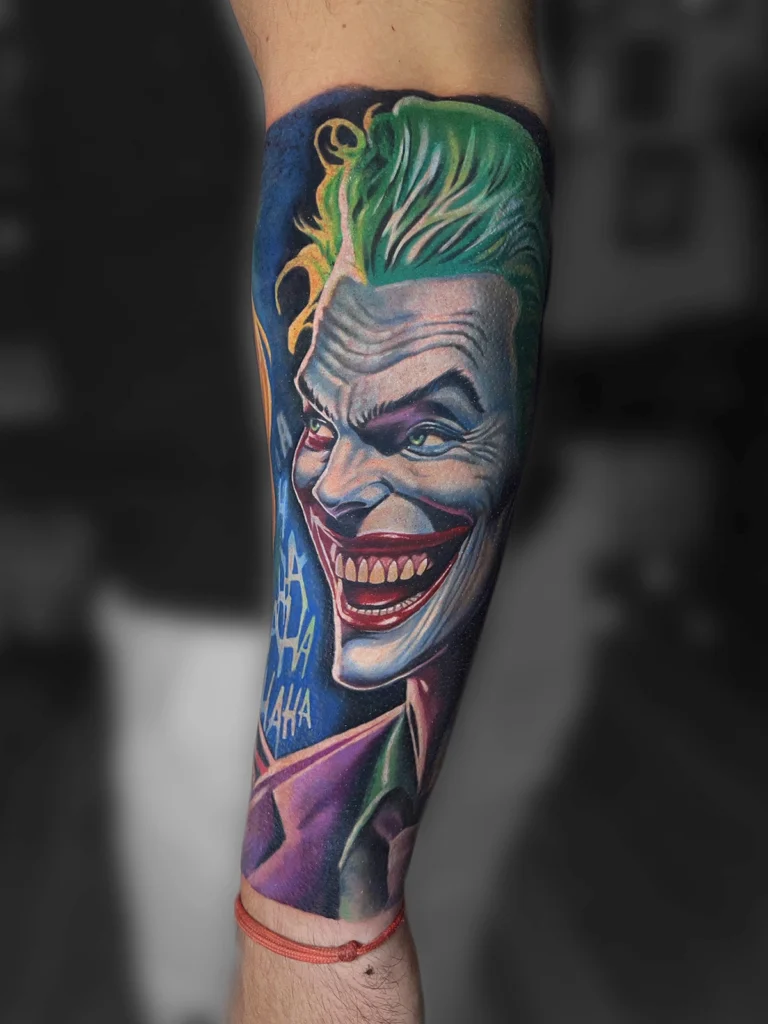 Kolorowy tatuaż realistyczny przedstawiający portret Jokera na przedramieniu wykonany w Studio Fortuna Tattoo Warszawa.